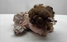 Load image into Gallery viewer, Brown Curly Hair And Blue Eyes Laying Down Girl Porcelain Doll In Pink Dress