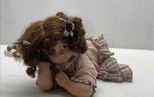 Load image into Gallery viewer, Brown Curly Hair And Blue Eyes Laying Down Girl Porcelain Doll In Pink Dress